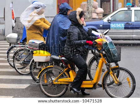 Chinese motorcyclist in shanghai street in a snowy day