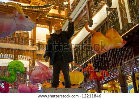 Chinese worker preparing decoration to the chinese new year in Shanghai street