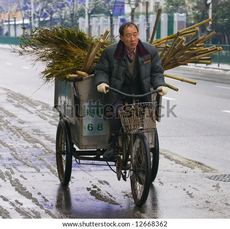chinese worker driving to work on his Tricycle