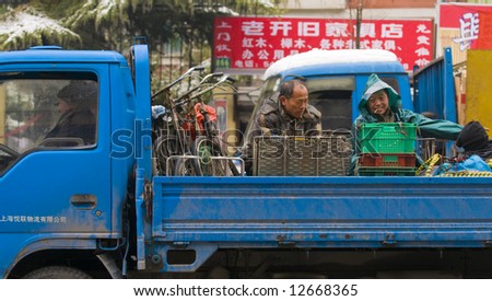 chinese workers on a truck in the way to work