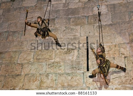 JERUSALEM - NOV 03 : An unidentified Israeli acrobats team dressed as knights climb on the old city walls in the annual medieval style knight festival held in the old city of Jerusalem on November 03, 2011