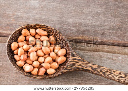 Peanut in wood spoon on wood background