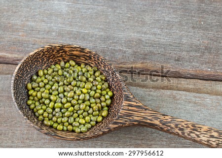 Green bean in wood spoon on wood background