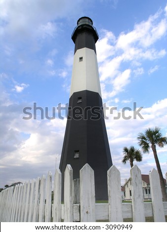 Black & White Lighthouse surrounded by a white fence