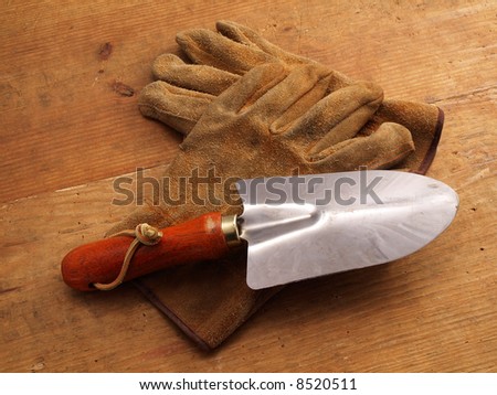 Two Work gloves crossed on wood with mini shovel