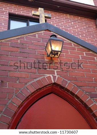 Church Cross above Red Brick Door Arch