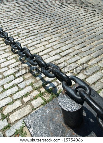 Heavy link Chain and Cobblestone street close up