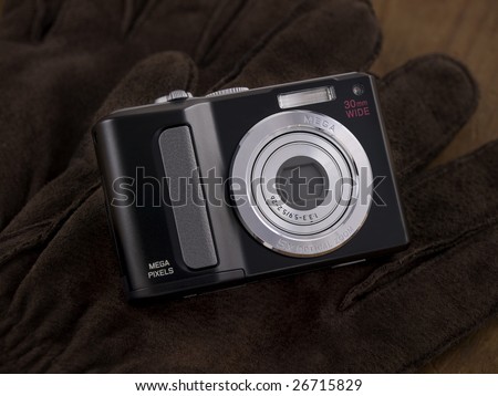 Point & Shoot Digital Camera placed on leather gloves