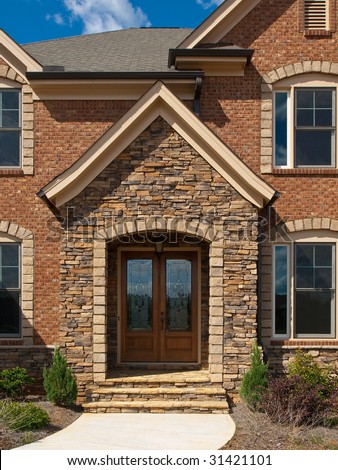 Luxury Model Home Exterior stone arch front entrance view
