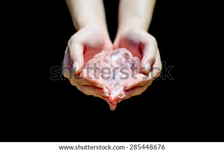 close up Ice cold on hands. Woman hands holding ice