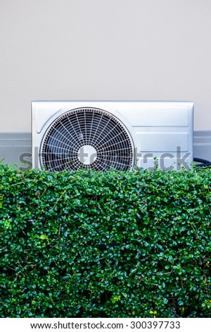 air compressor on wall with green tree