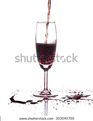 red wine pouring into wine glass isolated on white