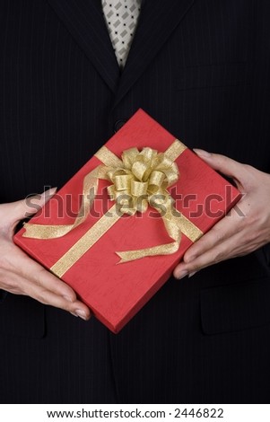 A business man holding a red gift box.