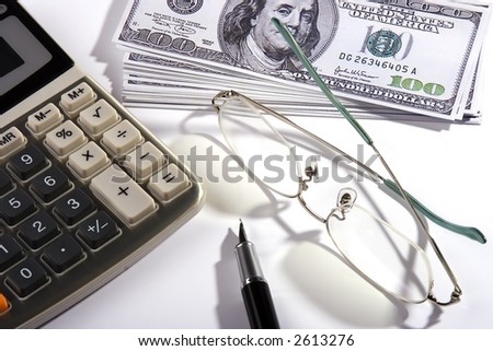 Close up shoot of calculator, US Dollar, eyeglasses and fountain pen.