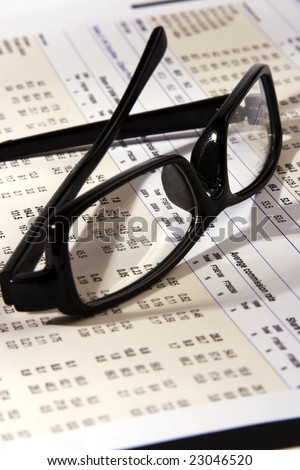 Eyeglasses on a financial statement with side light.