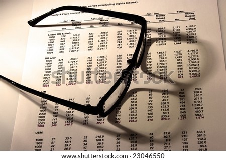 A Financial statement with a black frame eyeglasses.