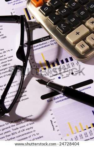 Financial statement with calculator, eyeglasses and fountain pen.
