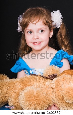 young smiling girl in blue dress with toy