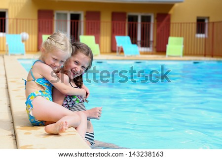 two little girls  near the open-air swimming pool