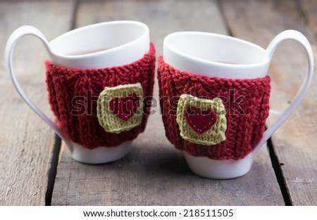 Knitted woolen cups on a wooden table