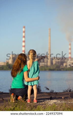care future concept. sisters are looking at the chimney-stalks polluting an air