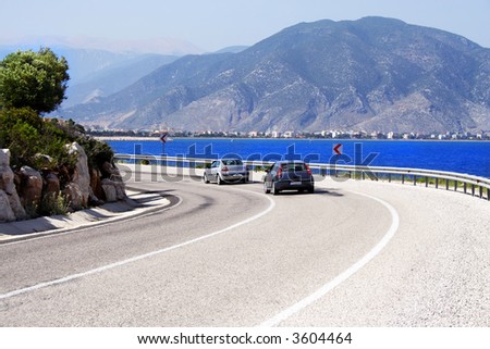 two cars on a sunny coastline road