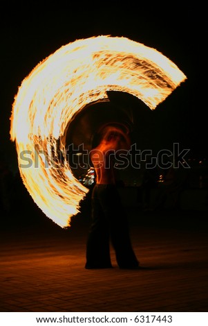 fire-eater performance on a street and audience on a dark background