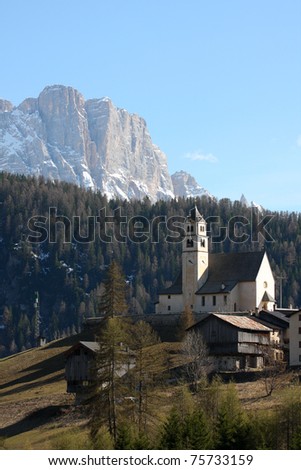 church on the hill with snowed mountains in the background, italy
