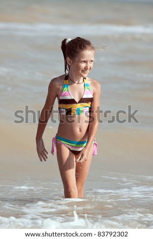 little smiling girl going out the sea.