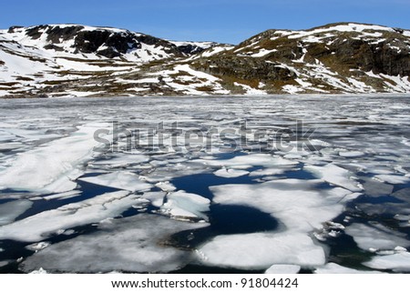 high mountain lake covered with the swimming ice-floes
