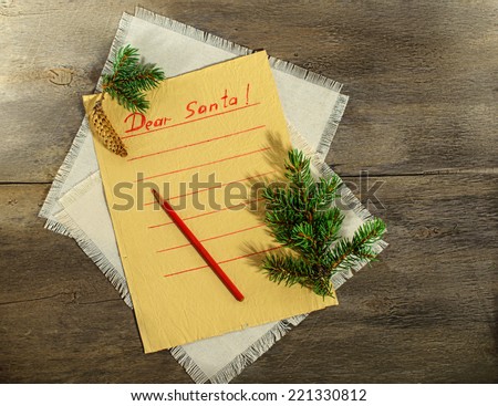 Child letter to Santa Claus. Blank yellow lined paper with branch of christmas tree and pencil on the wooden background