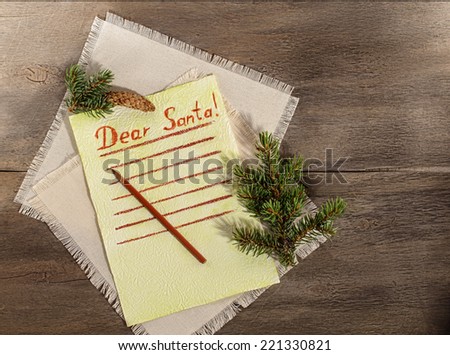 Child letter to Santa Claus. Blank lined paper with branch of christmas tree and pencil on the wooden background