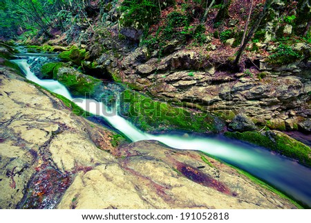Mountain forest stream flowing between the rocks. Vintage style