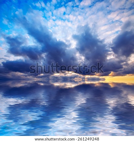 bright sunset and dramatic clouds at calm sea background. Natural composition