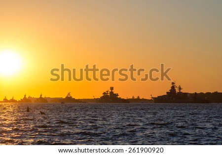 Silhouette row of warships in the Bay of Sevastopol against the setting sun