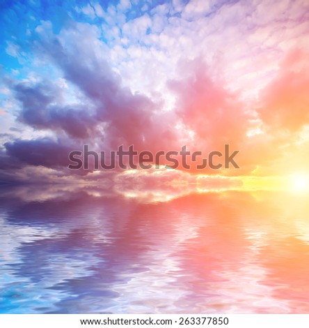 bright sunset and dramatic clouds with sun at calm sea background. Natural composition
