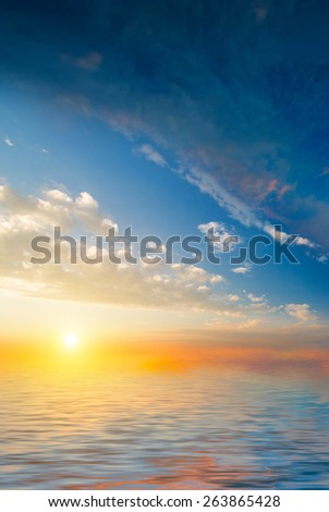 Beautiful sunset on the background of the calm sea and clouds. natural composition