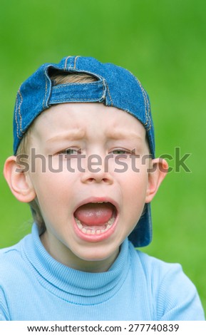 Little boy in denim cap indulges, pretending that she was crying. Family composition