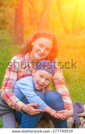 Son of laughs and screams, hugging her mother\'s lap. Family composition