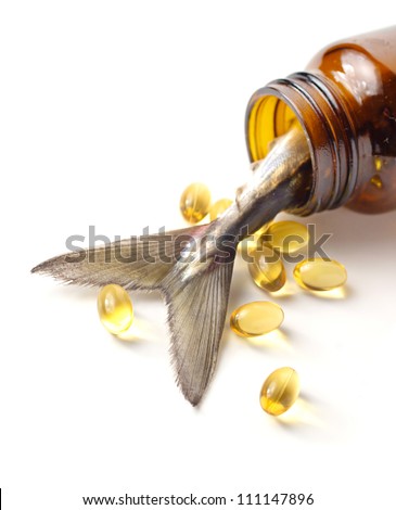 Fish oil capsules / tablets / pills, and fish tail  tipping out of glass jar / container / bottle, isolated on white background with shadow