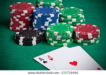 Pair of aces on a poker table with poker chips next to them