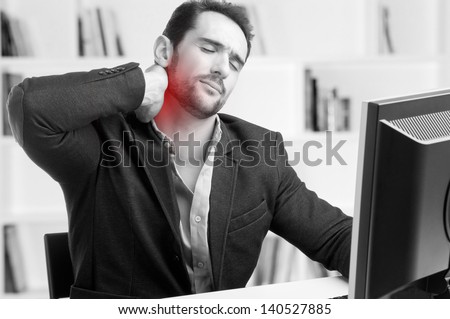 Casual businessman sitting in a desk with pain in his neck, black and white, red dot around painful area