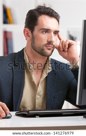 Man looking at a computer screen, thinking about the job at hand