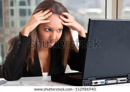 Worried businesswoman looking at a computer screen in an office