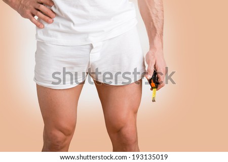 Concept of a man with a small penis with a measuring tape in the hand