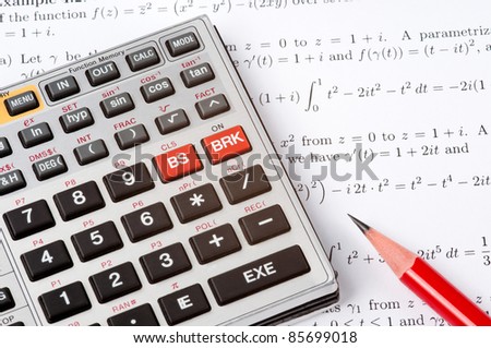 Scientific calculator and a red pencil on top of a sheet of paper with maths formulas