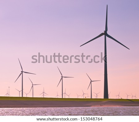 Giant 3 Megawatt Wind Turbines along the Sea Dike in the Netherlands seen from the Water