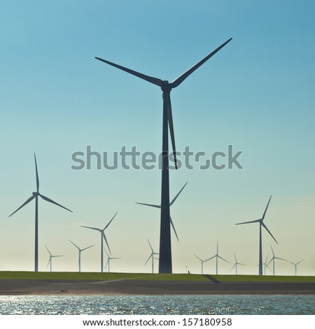 Giant 3 Megawatt Wind Turbines along the Sea Dike in the Netherlands seen from the Water