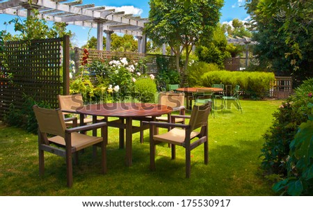 Landscaped Garden With Wooden Dining Table Set In The Shade Of Trees