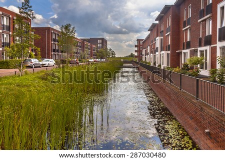 Modern Street with ecological middle class family houses with eco friendly river bank in Wageningen city, Netherlands